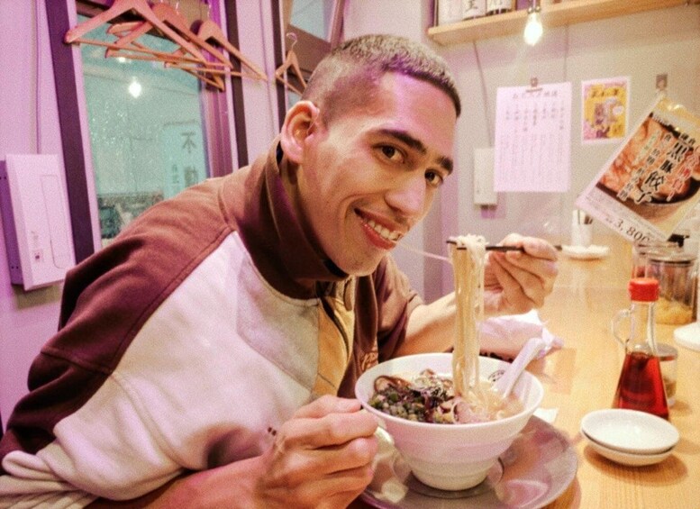 A person eating noodles from a bowl with chopsticks. 5