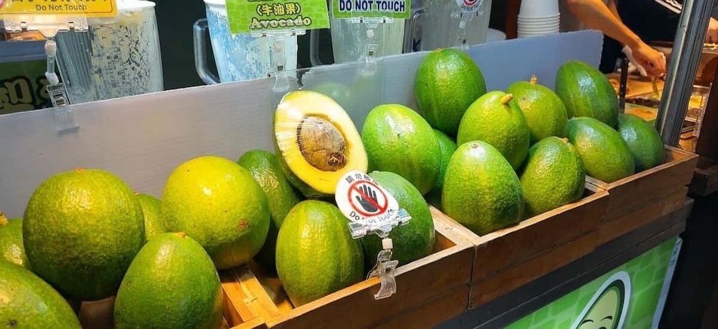 A display of avocados with a 'Do Not Touch' sign. 1