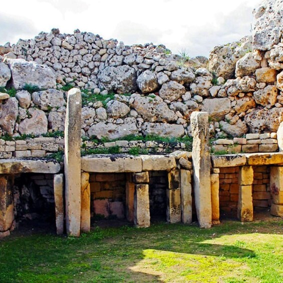 Ancient stone ruins with columns and a stone wall. 4