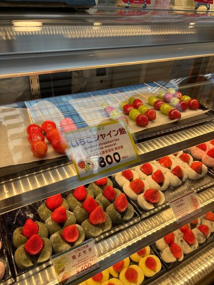 A display case with various Japanese sweets, including candied strawberries and other colorful confections. 5
