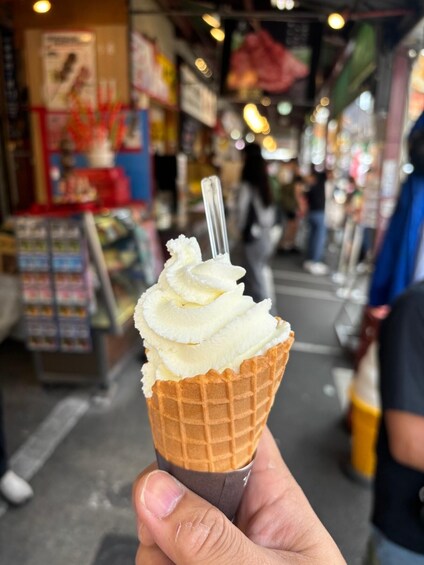 A hand holding a waffle cone with a scoop of ice cream. 4