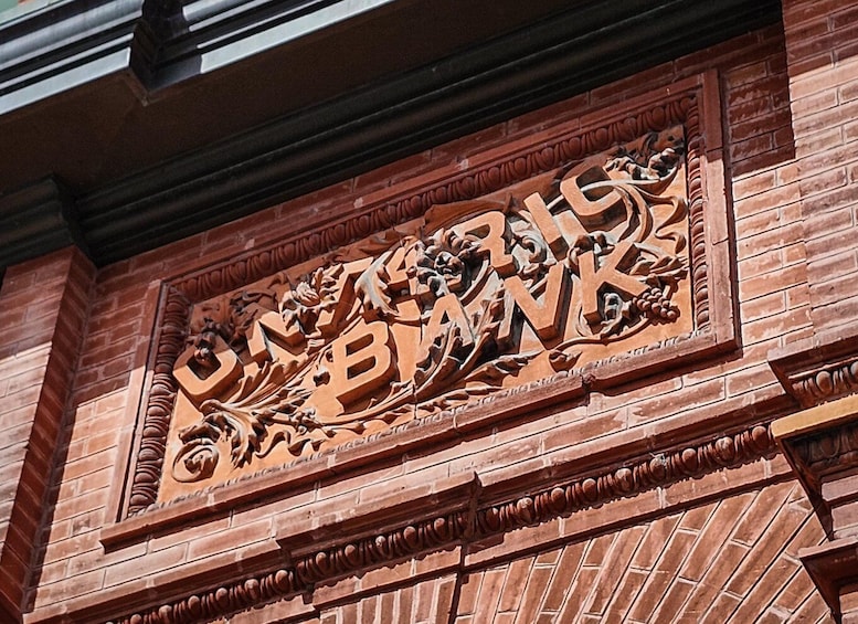 A detailed stone carving with the inscription 'BANK' on a brick wall. 2