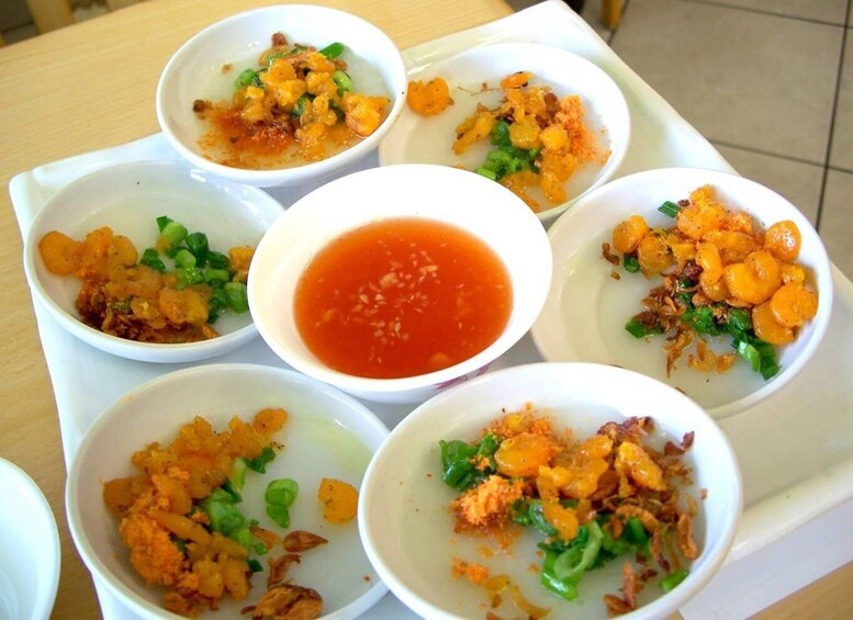 A tray with bowls of food, including a central bowl of red sauce. 4