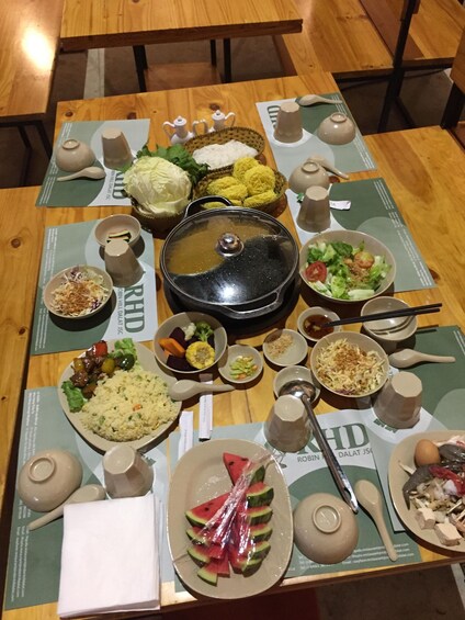 A table with various dishes, including rice, vegetables, and a covered pot, likely for a meal. 5