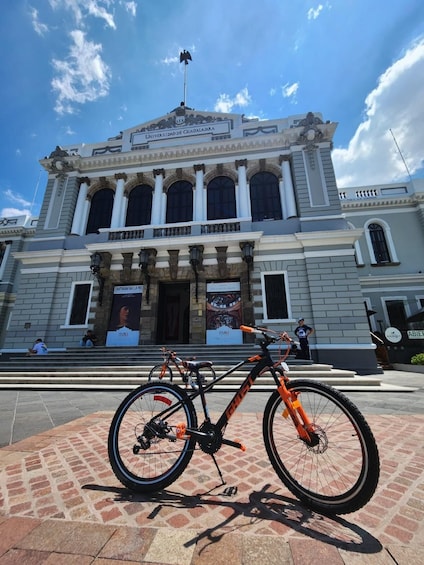A historic building with a prominent entrance and a bicycle parked in front. 4