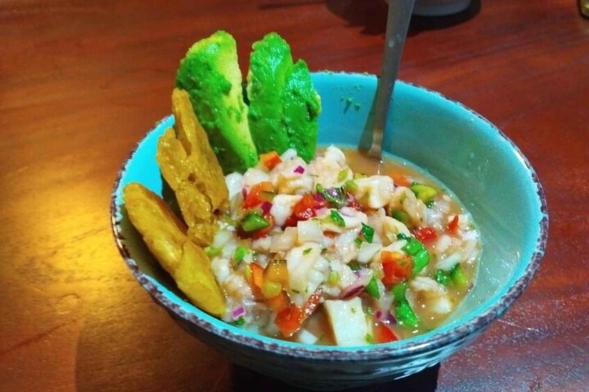 A bowl of ceviche with avocado and red onions. 1