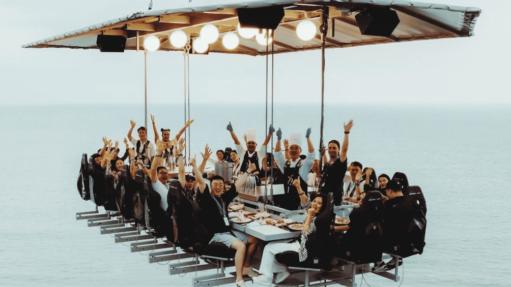 A group of people dining on a boat with an open-air dining setup. 1