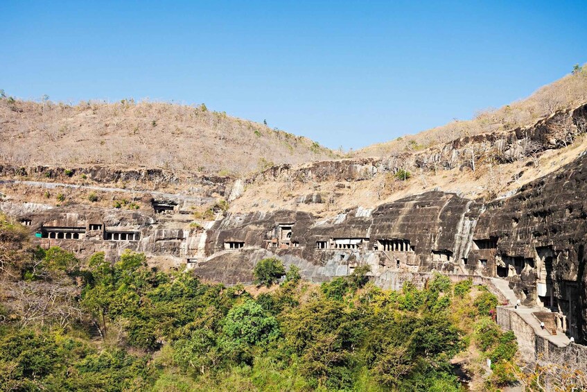 Ancient rock-cut architecture with multiple structures carved into the hillside. 4