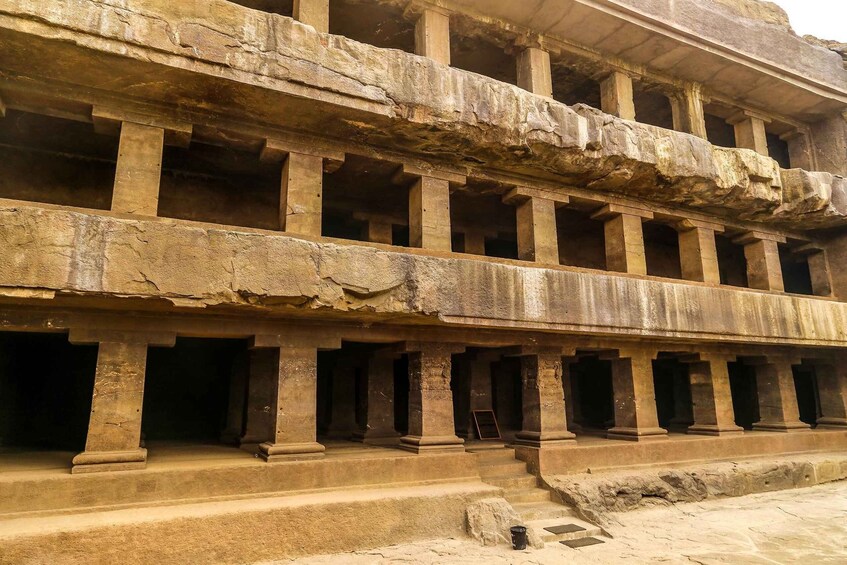 A multi-tiered ancient stone structure with columns and open spaces. 5