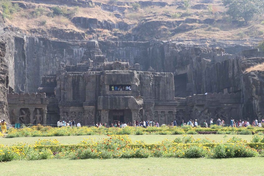 A historic temple complex with intricate carvings and a large crowd of visitors. 3