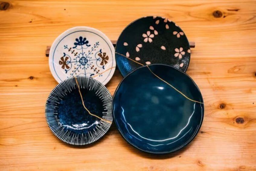 Four ceramic plates on a wooden table. 1
