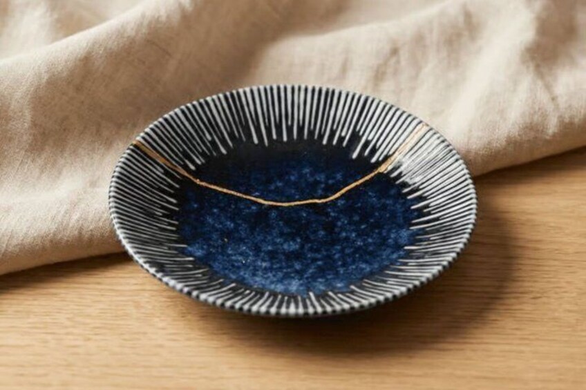 A bowl with a blue substance on a wooden surface. 5