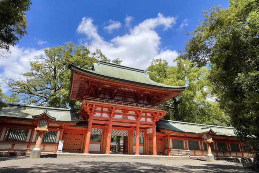 A traditional Japanese temple with a red torii gate, surrounded by trees. 1