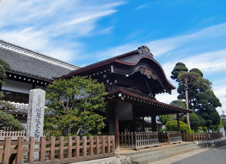 A traditional Japanese building with a curved roof and wooden fence. 4