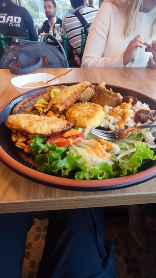 A meal with various dishes including a salad, roasted chicken, and fried items on a plate. 3