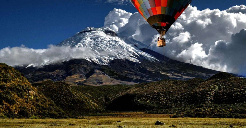 A hot air balloon flying over a snow-capped mountain with a clear sky. 3