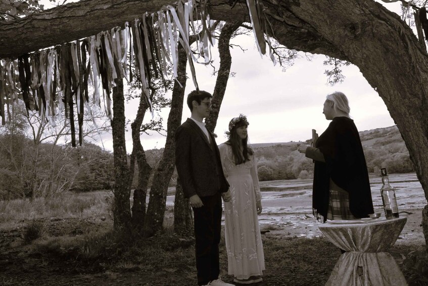 A couple under a tree with icicles, a table with bottles, and a rural landscape. 3
