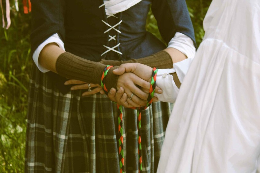 Two people holding hands with a green plaid skirt and a dark top. 5