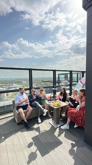 A group of people sitting on a rooftop terrace with a cityscape view. 3