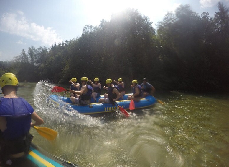 A group of people rafting on a river, wearing helmets and life jackets. 1