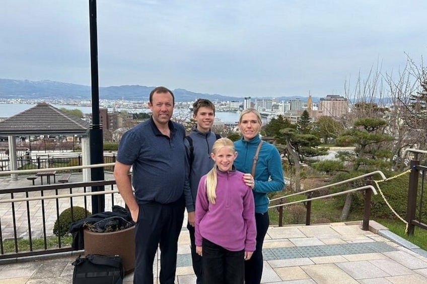 A group of people standing on a staircase with a cityscape in the background. 3