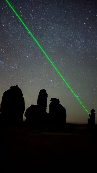 A starry night sky with a green laser beam. 1