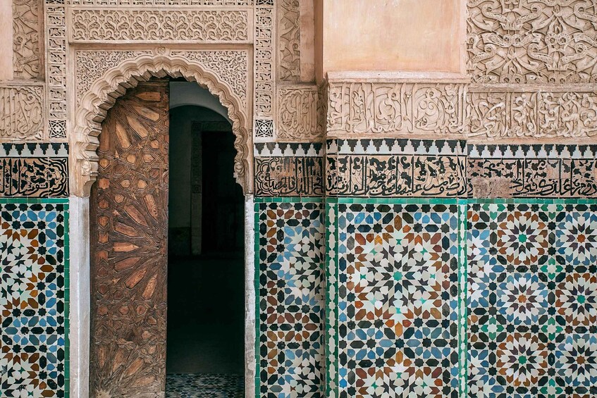 An ornate doorway with intricate tile work and Arabic calligraphy. 4