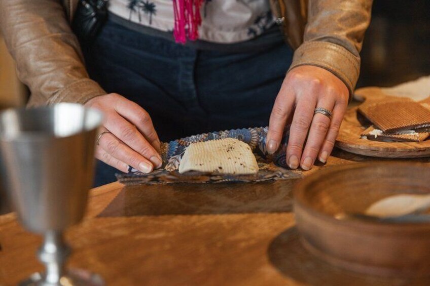A person handling a woven basket on a wooden table. 4