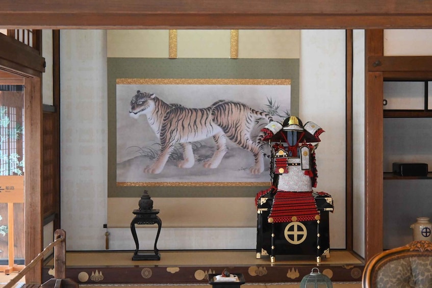 A traditional Japanese room with a tiger painting, a ceremonial chair, and a lantern. 4