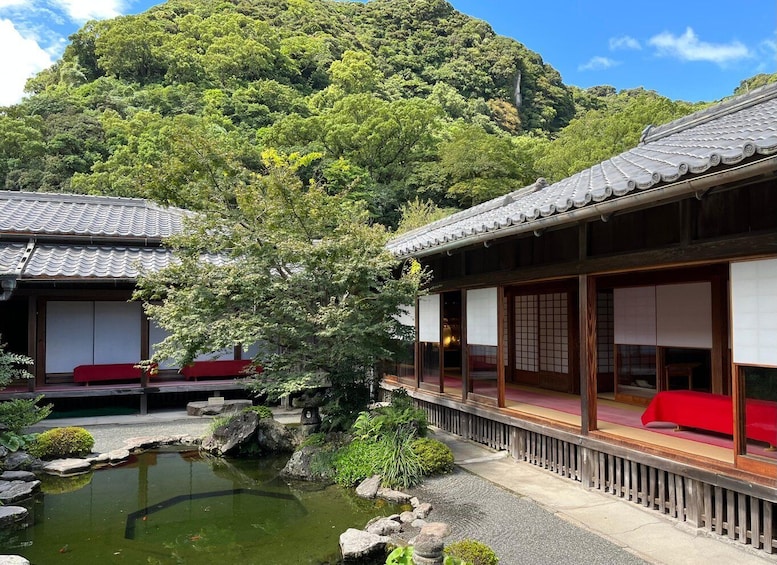 A traditional Japanese building with a koi pond and a mountain backdrop. 2
