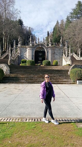 A person standing in front of a grand staircase leading to a building with ornate architecture. 2