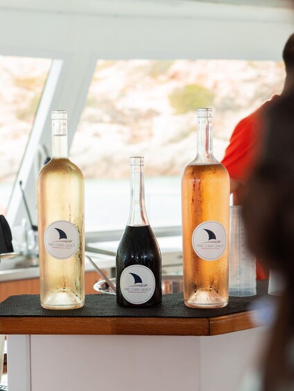 Three bottles of wine with labels on a counter. 3