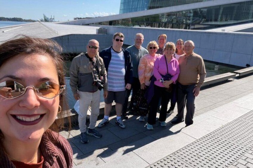 A group of people standing on a rooftop with a modern building in the background. 1