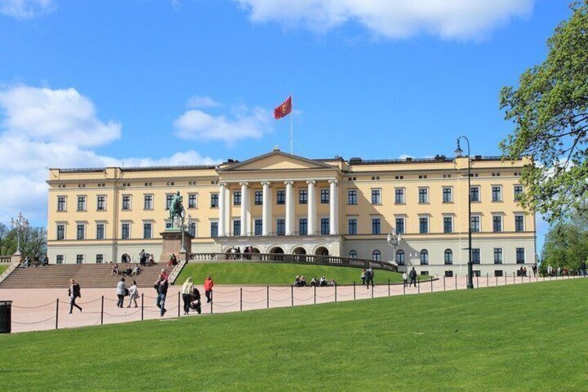 A large, classical building with a flag, steps leading up to it, and a well-maintained lawn in front. 4