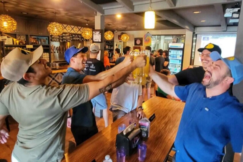 A group of people toasting with drinks at a bar. 2