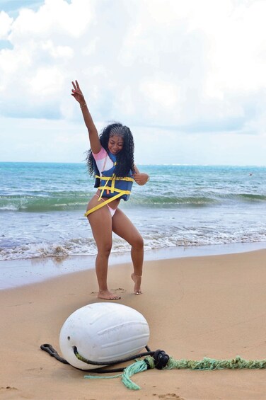 A person on a beach with a surfboard and a rope. 2