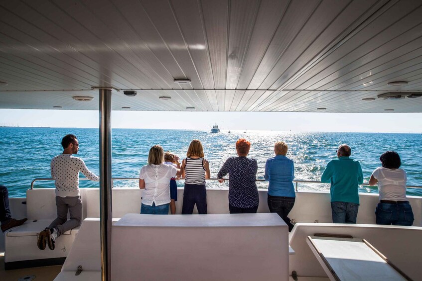 A group of people on a boat, looking out at the sea. 2