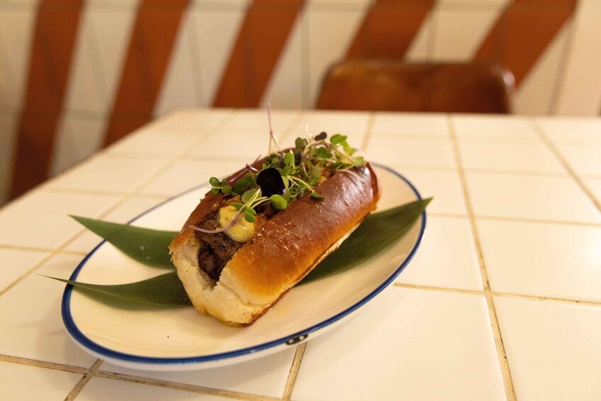 A sandwich on a plate with a green leaf garnish. 5
