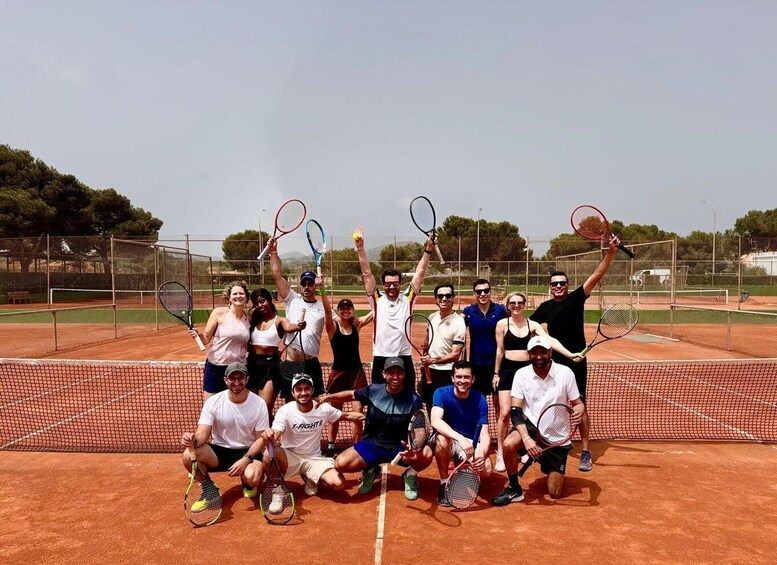 A group of people on a tennis court holding tennis rackets. 1