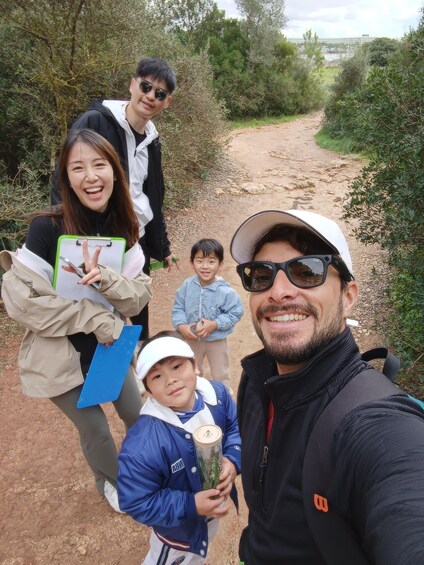A group of people on a dirt path surrounded by greenery. 3