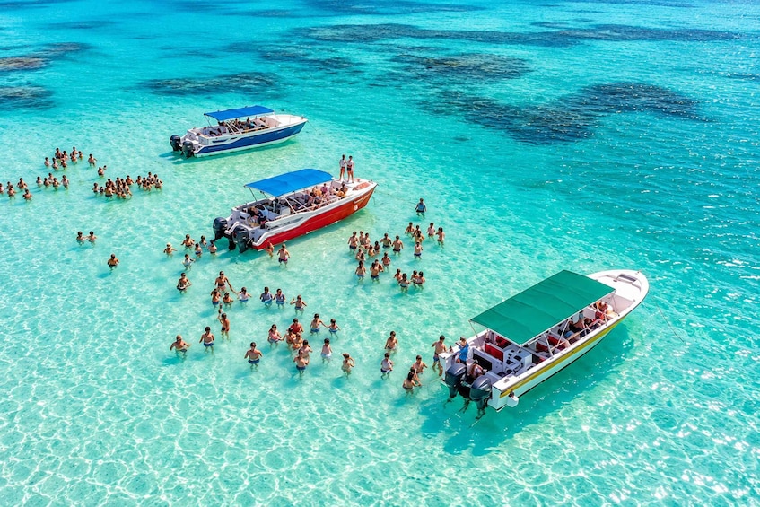 A group of people on a boat in clear turquoise waters. 1