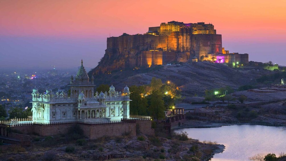 A historic fort and palace complex with a river in the foreground. 2