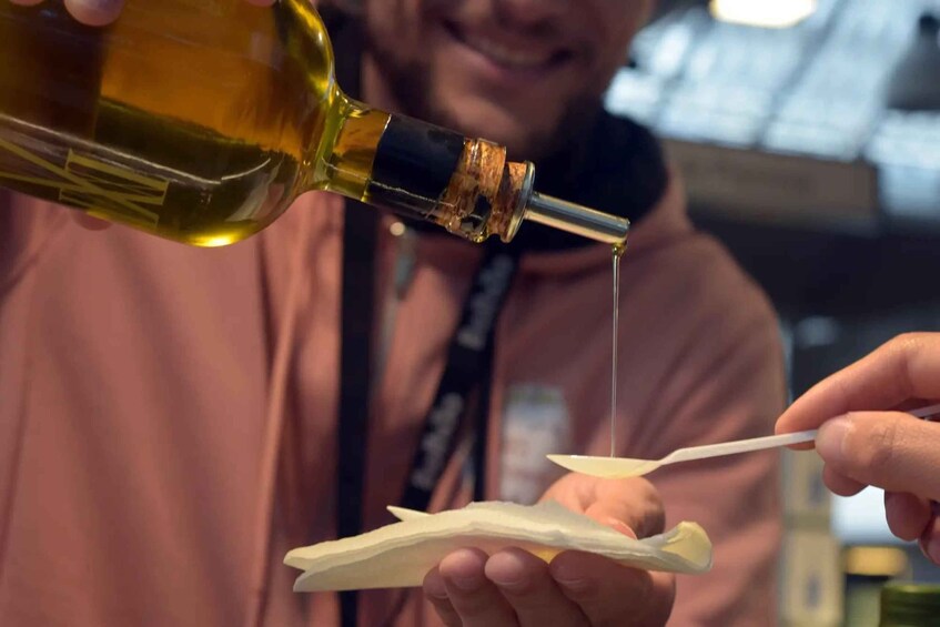 A person pouring olive oil onto a piece of bread. 4