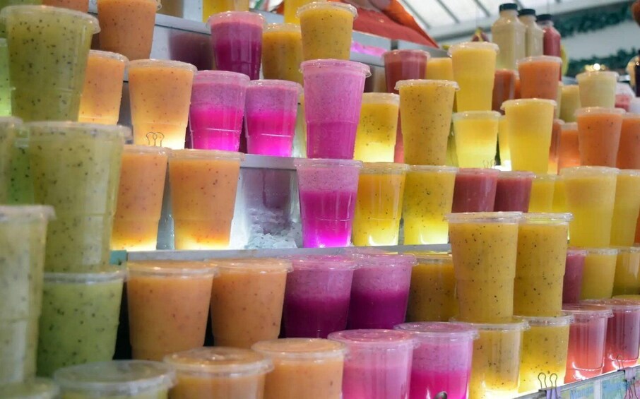 A variety of colorful smoothies in plastic cups. 1