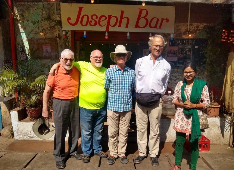 A group of people standing in front of a bar named 'Joseph Bar'. 5