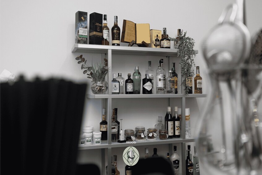 A shelf with various bottles and boxes, including a book and decorative items. 1