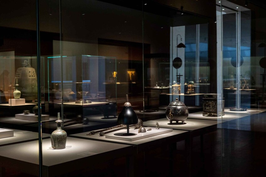 Une exposition dans un musée, avec des vitrines contenant divers objets d’époque. 5