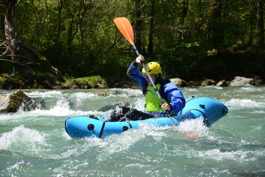 A person kayaking on a river surrounded by trees. 1