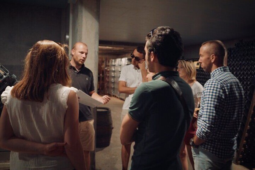 A group of people in an indoor setting, possibly a warehouse or storage facility, with shelves in the background. 3