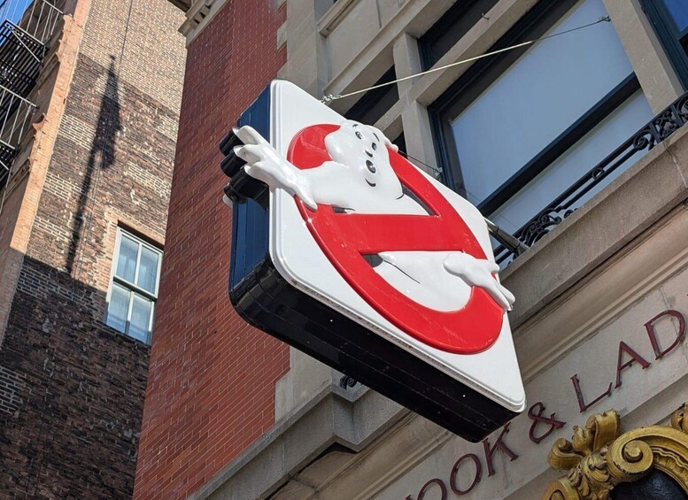 A no parking sign with a white and red design, mounted on a building with a brick facade and a sign reading 'Book & LADY.' 1